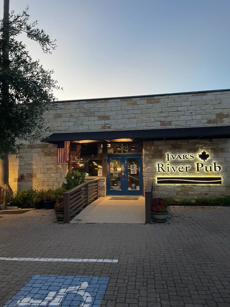 Ivar's River Pub stone entrance with illuminated sign at dusk