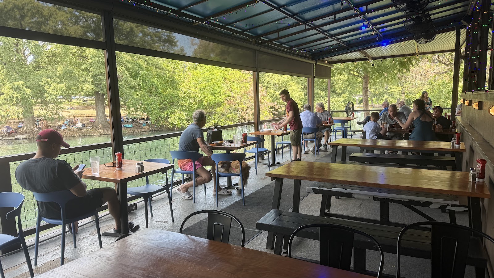 Guests dining on the deck at Ivar's River Pub with river views