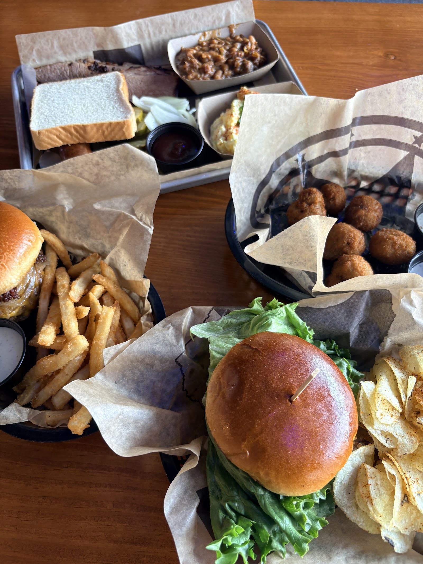 Brisket plate, burger and fried hush puppies on the table